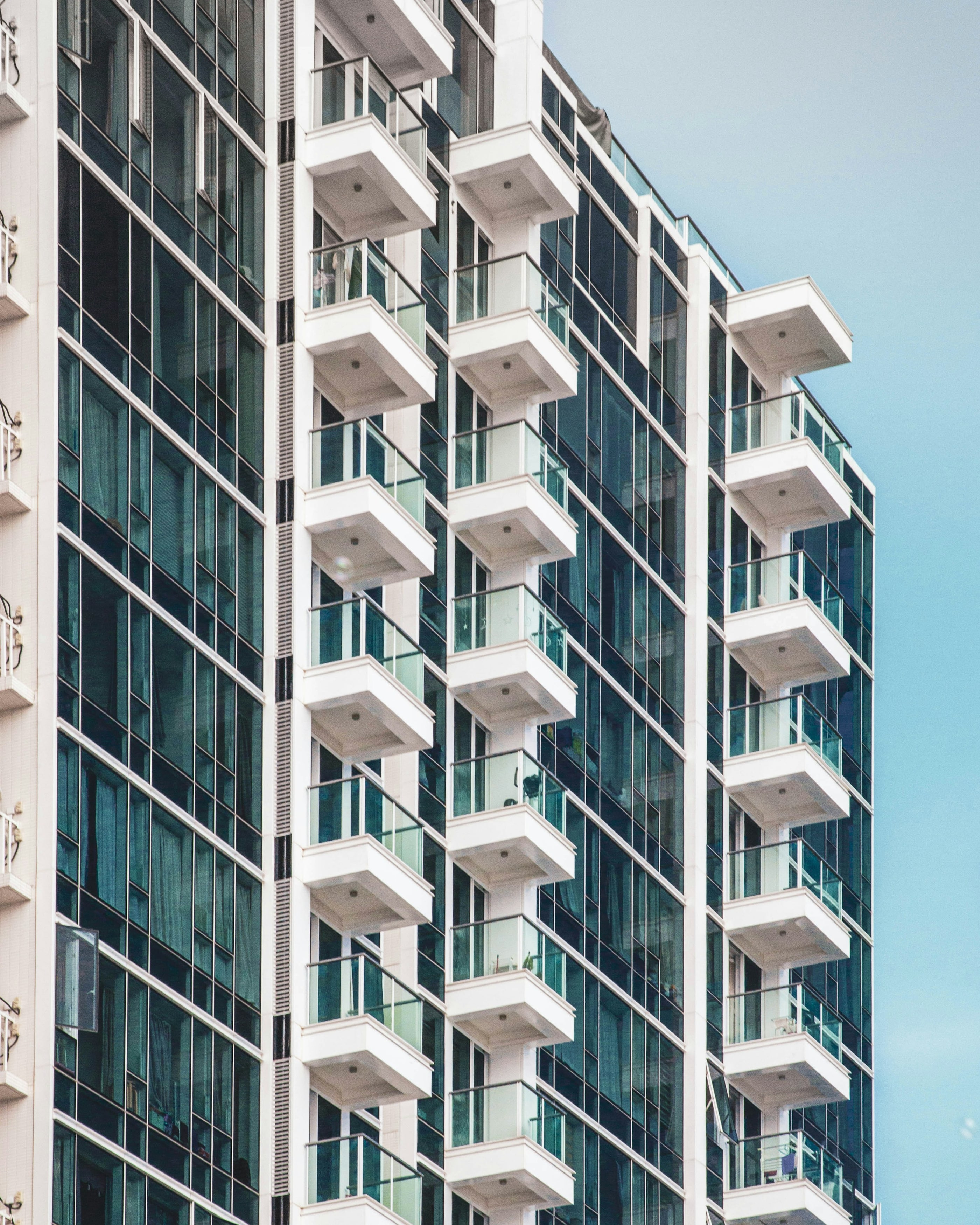 Torre residencial branca com varandas iguais em todos os andares